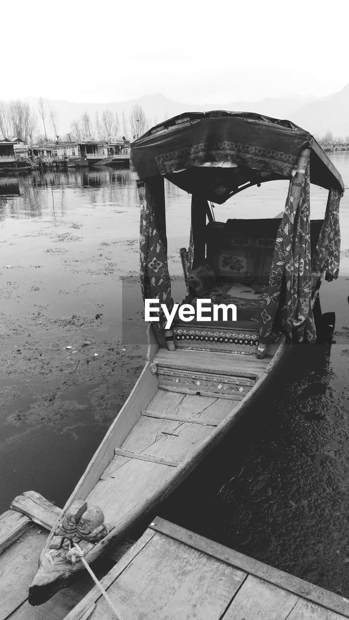 BOAT MOORED AT LAKE AGAINST SKY