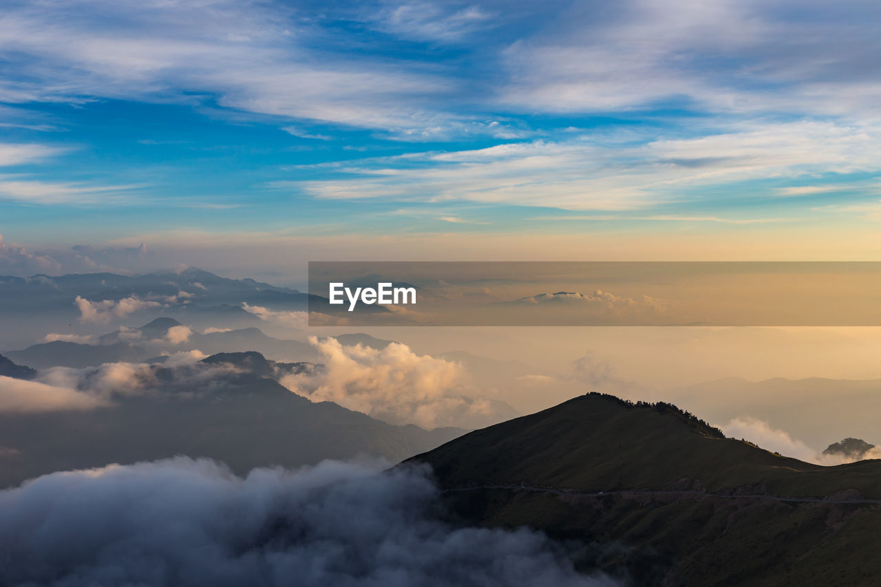 Aerial view of clouds covering volcanic landscape against sky during sunset