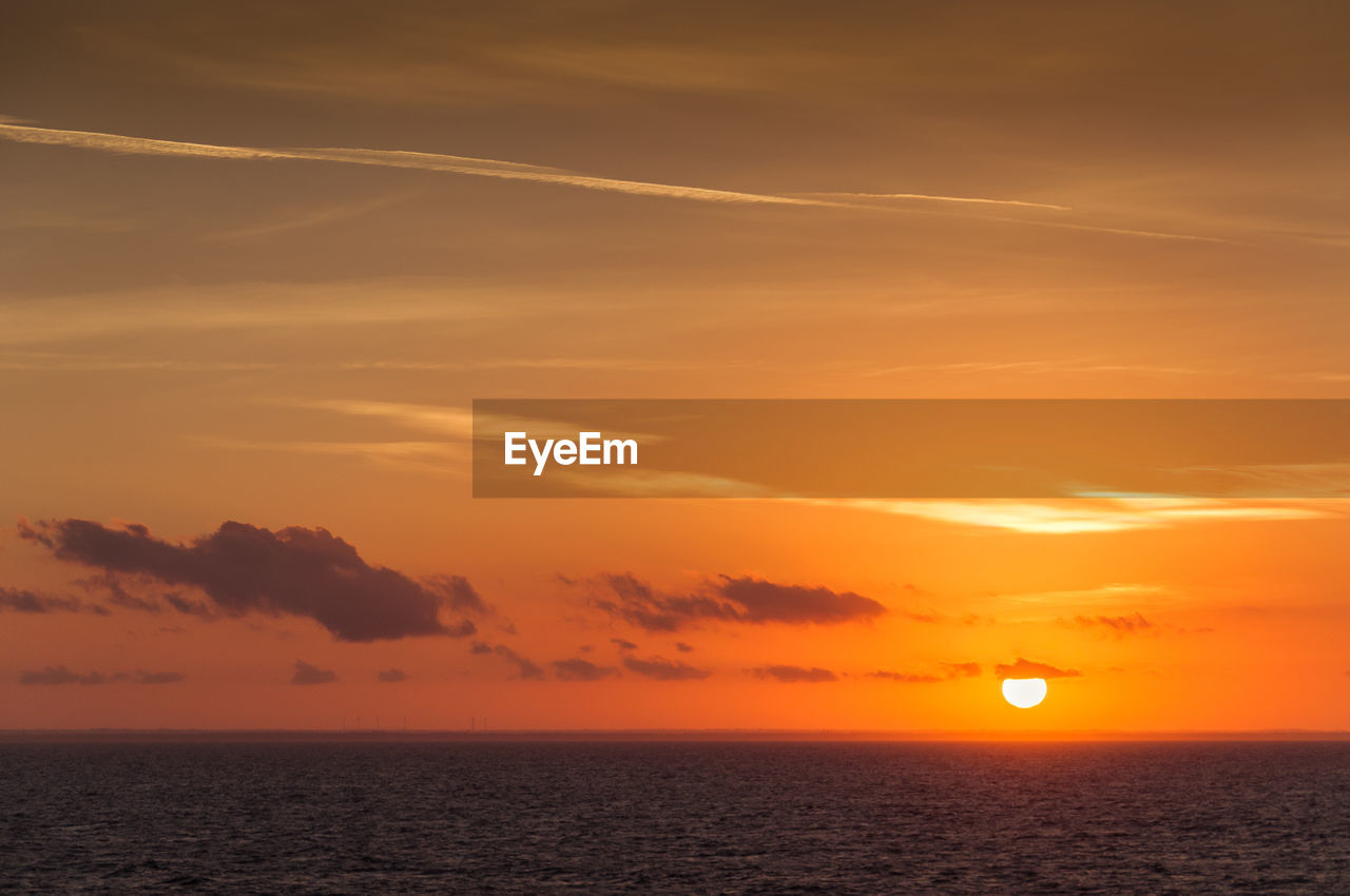 SCENIC VIEW OF SEA AGAINST ORANGE SKY DURING SUNSET