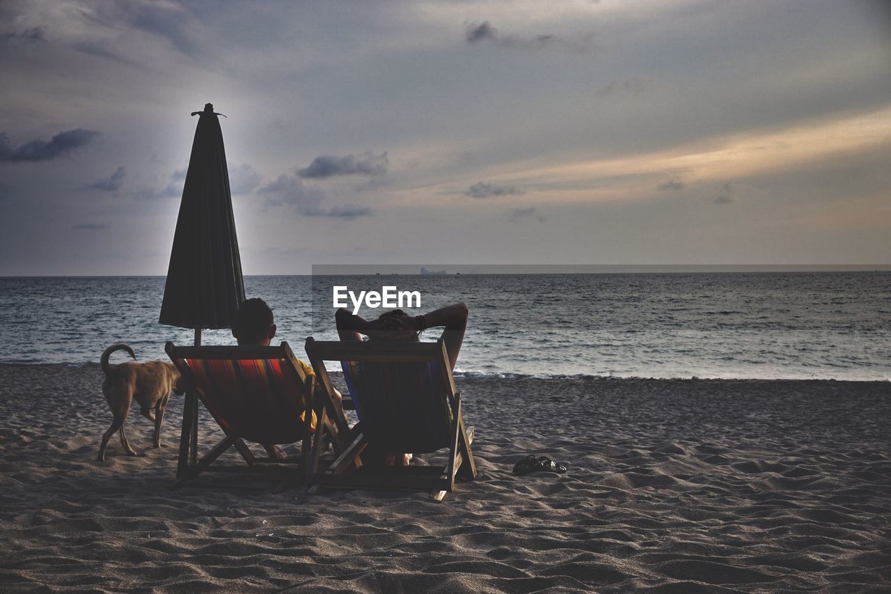 CHAIRS ON BEACH BY SEA AGAINST SKY