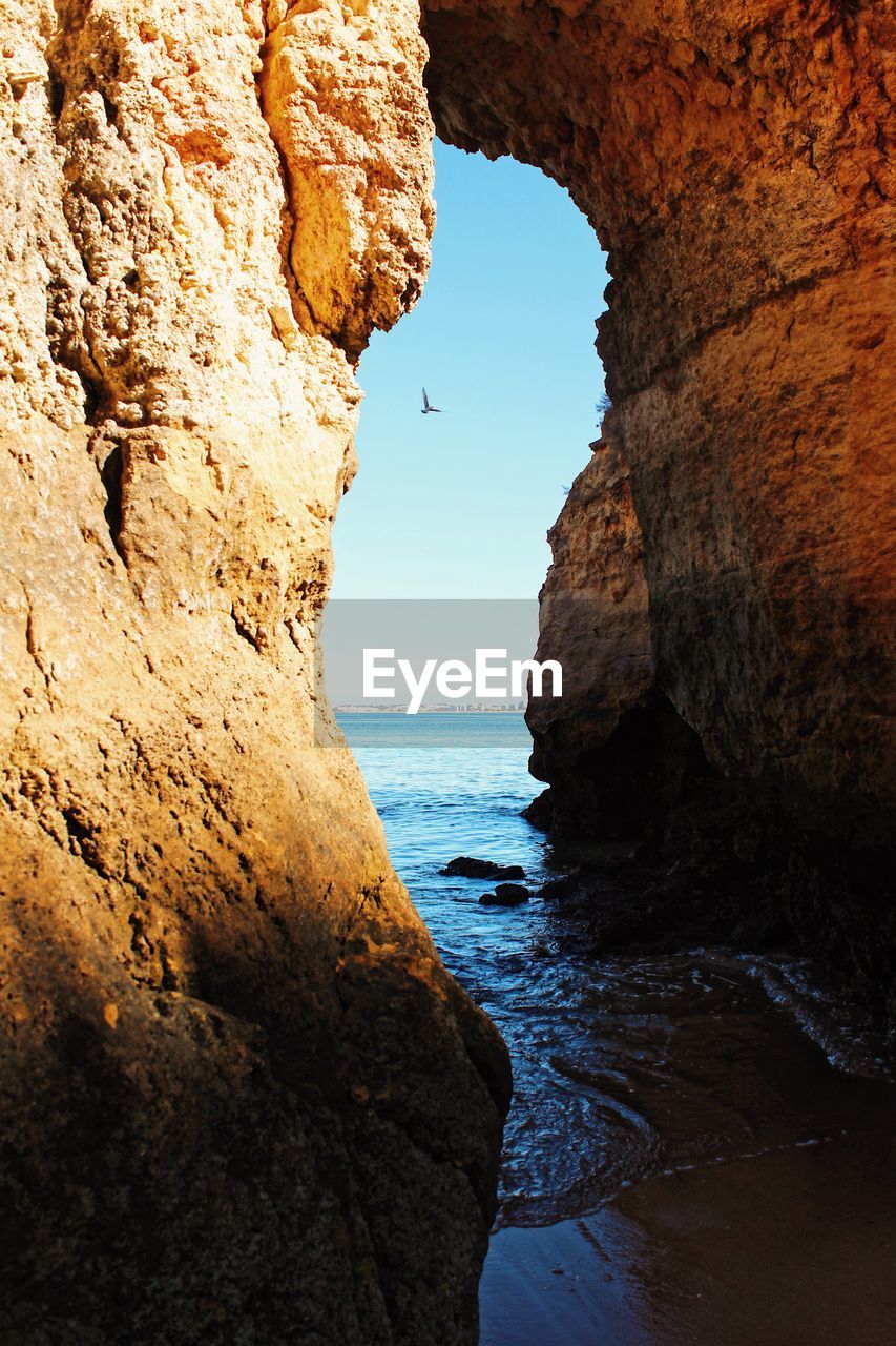 Rock formations by sea against sky