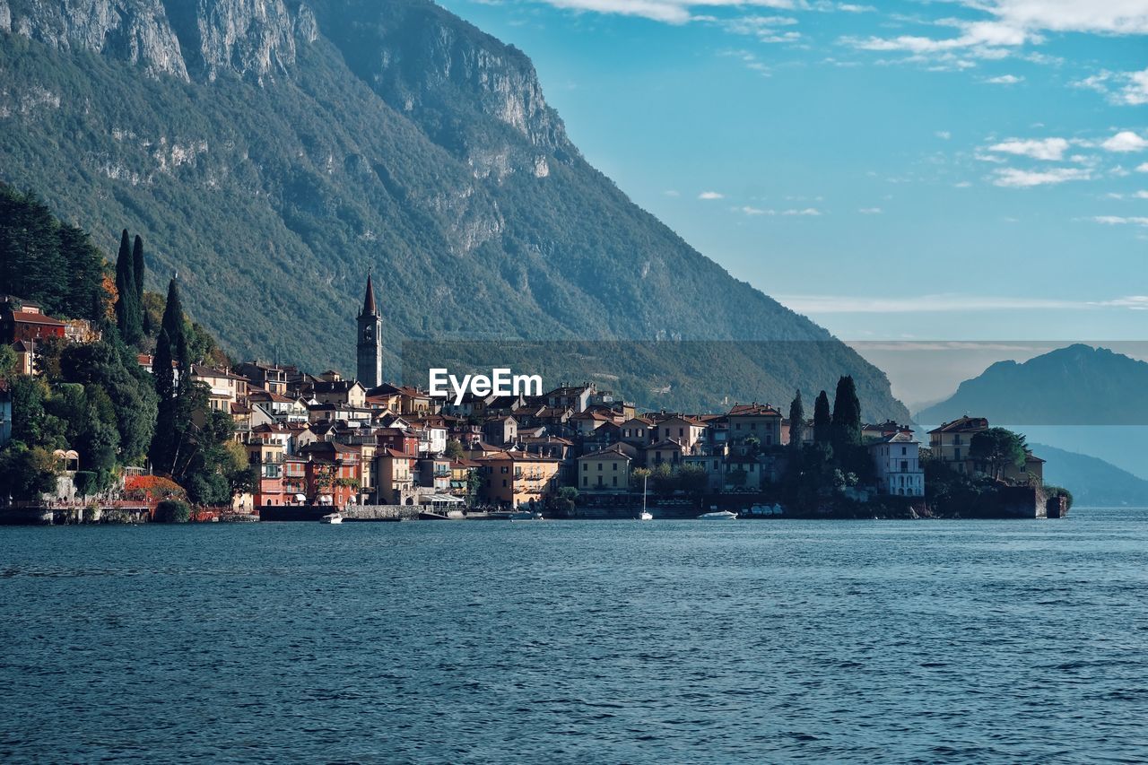 Scenic view of town by sea against sky