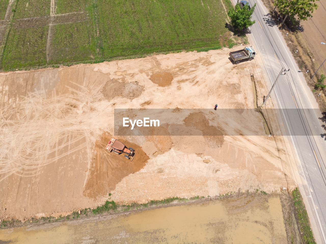 HIGH ANGLE VIEW OF MAN ON ROAD AMIDST LAND