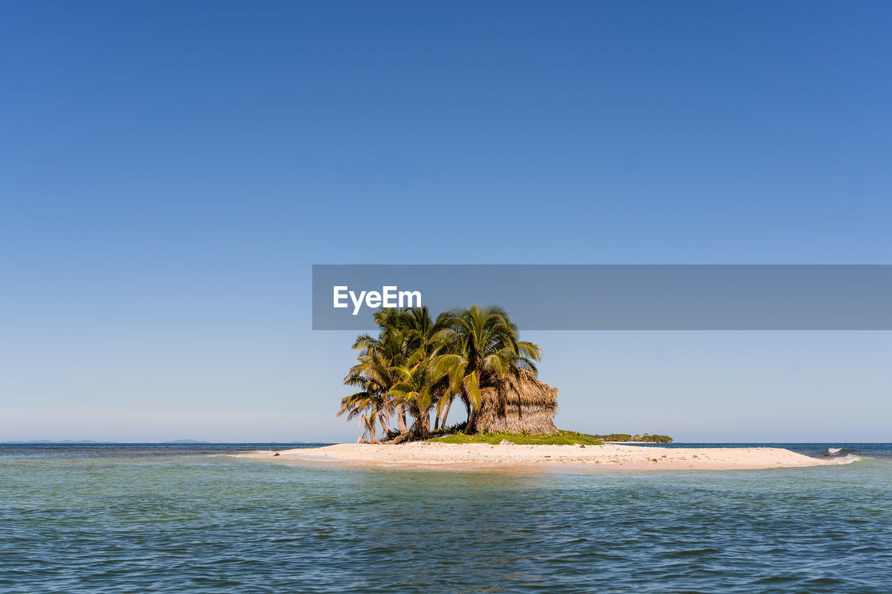 Scenic view of sea and island against clear sky