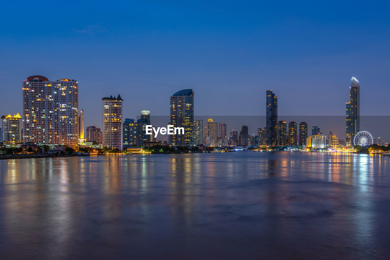 ILLUMINATED BUILDINGS IN CITY AGAINST SKY