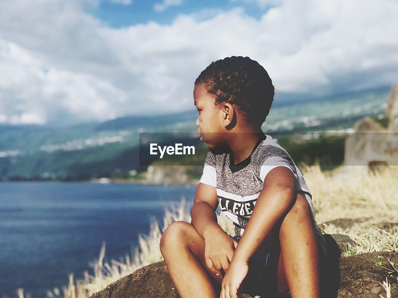 BOY SITTING ON BEACH