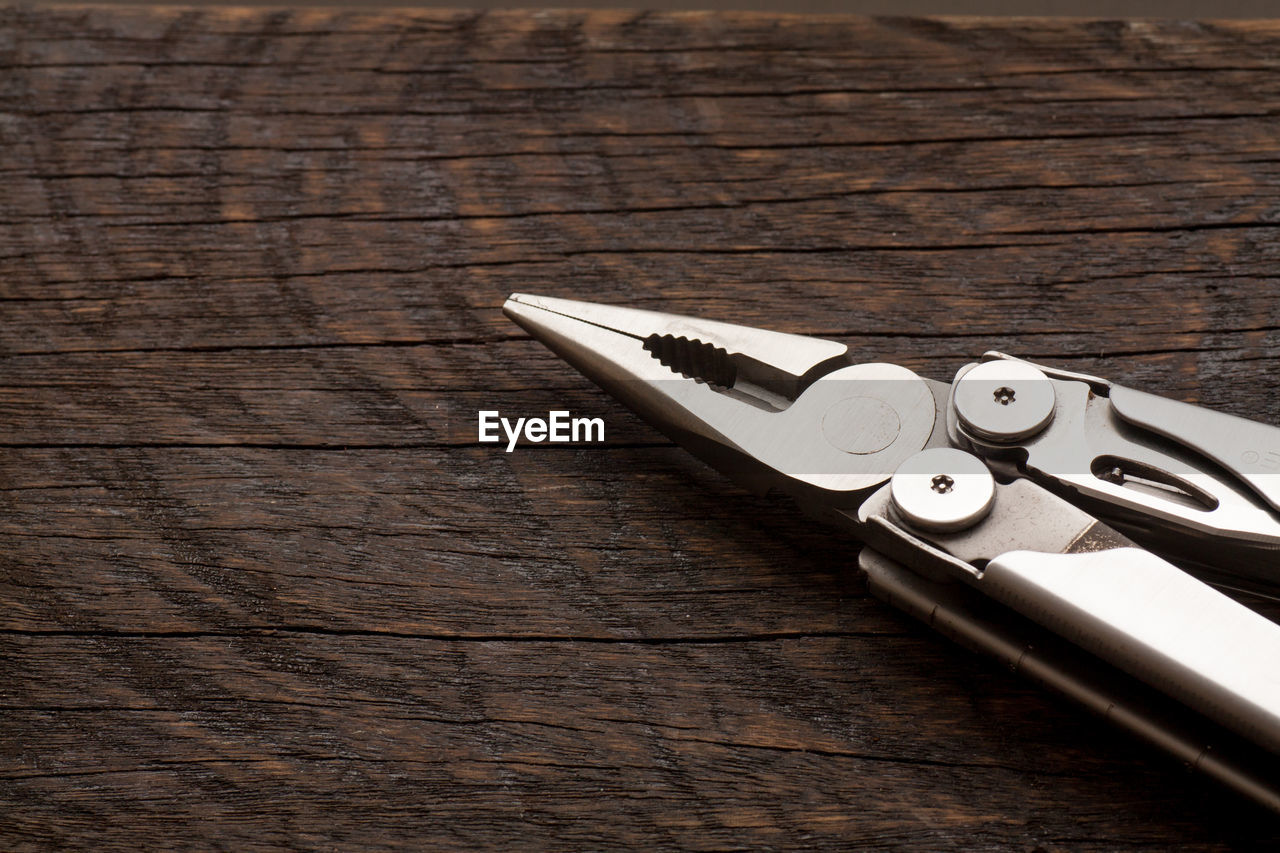 High angle view of pliers on wooden table