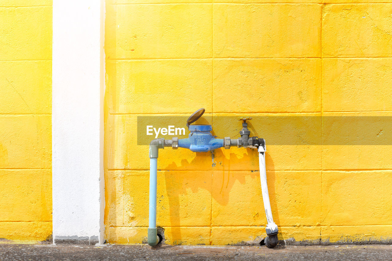 CLOSE-UP OF A YELLOW WALL WITH UMBRELLA