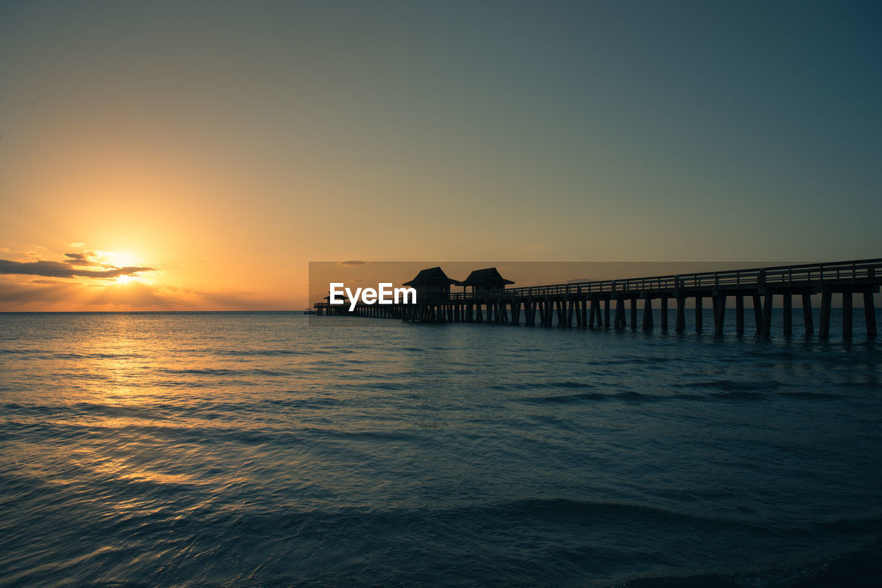 Naples pier at sunset with copy space