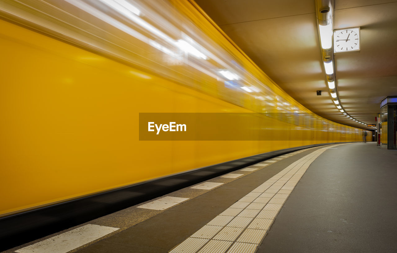 Blurred motion of yellow train at railroad station