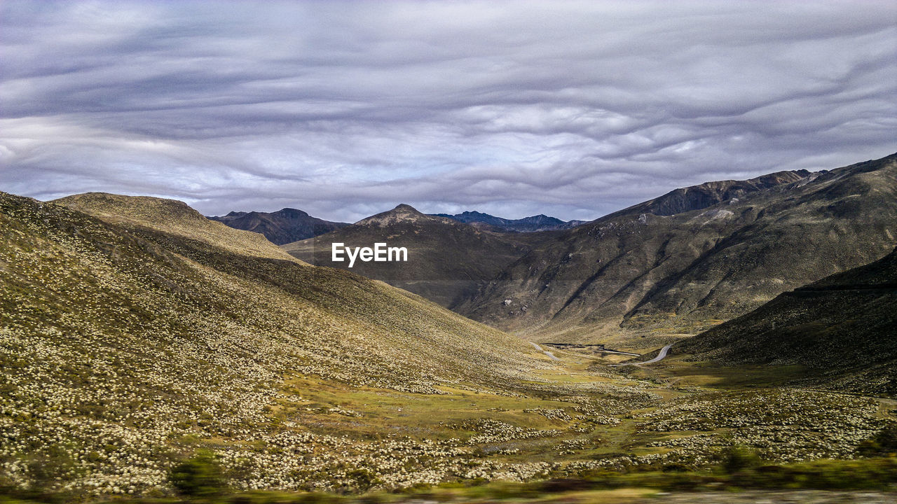 Scenic view of mountains against cloudy sky