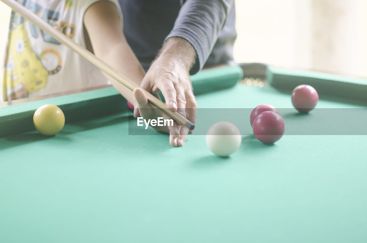 Midsection of people playing pool