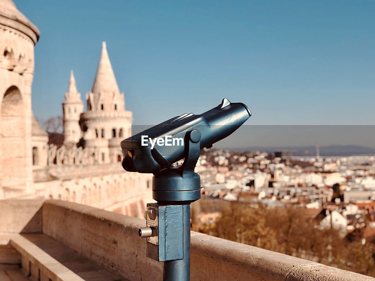 Close-up of coin-operated binoculars against buildings in city