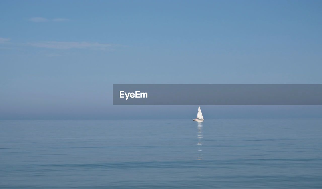 Sailboat sailing in sea against clear sky