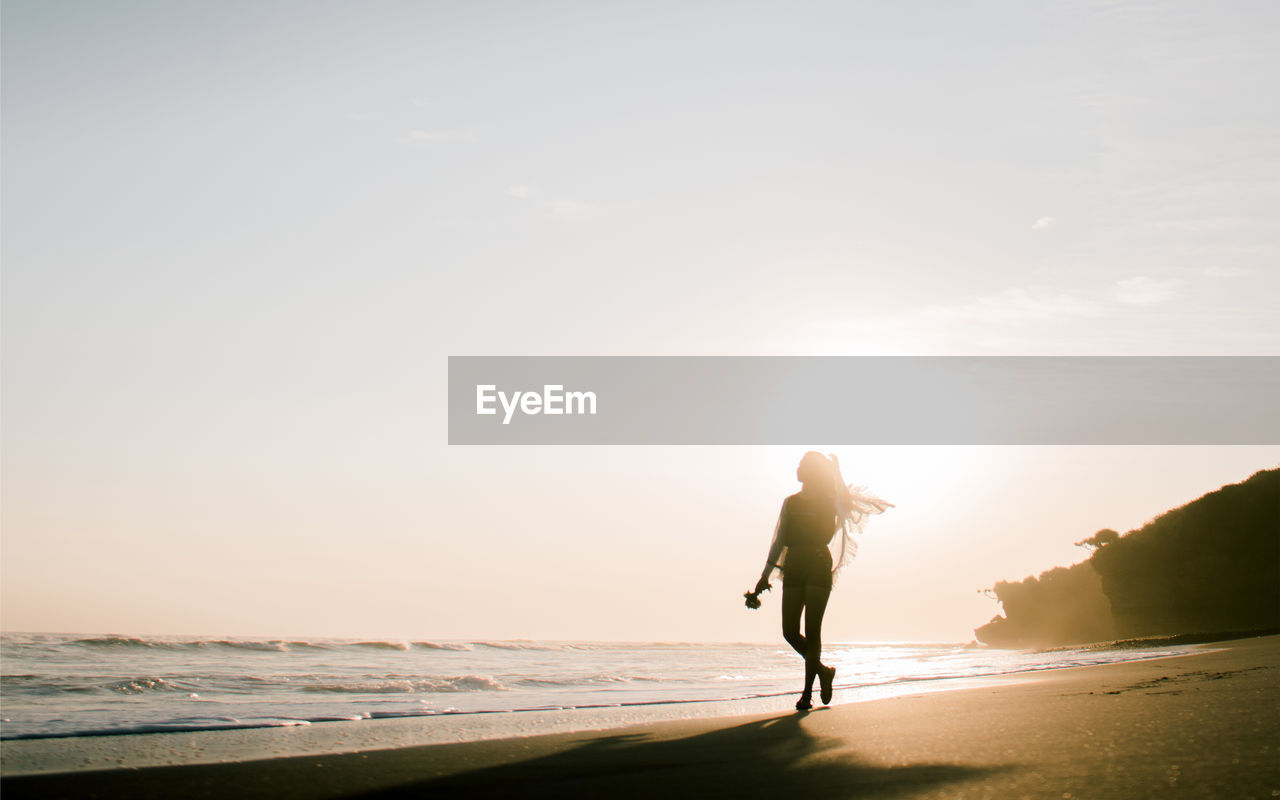 Full length of woman on beach against sky