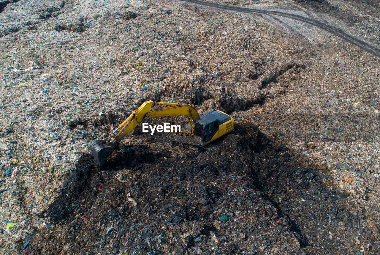 A lot of waste is disposed of in the waste disposal pits. loaders is working on a mountain garbage.