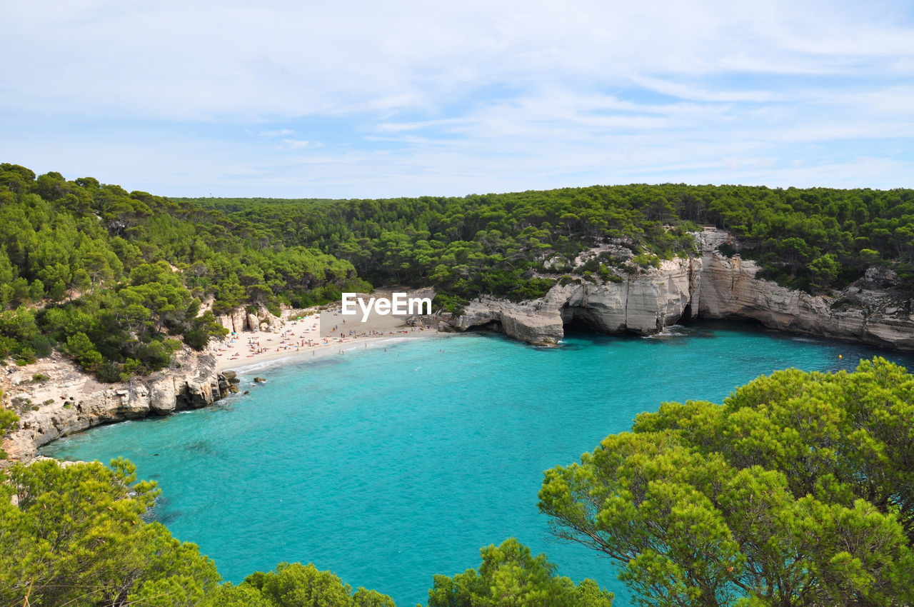 High angle view of sea surrounded by trees against sky