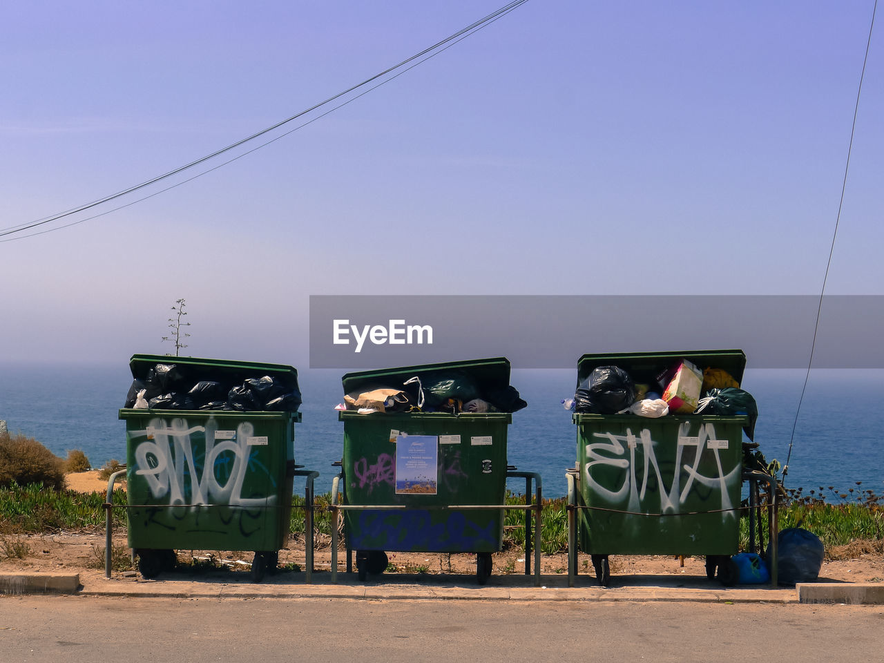 Garbage can on ground against sky