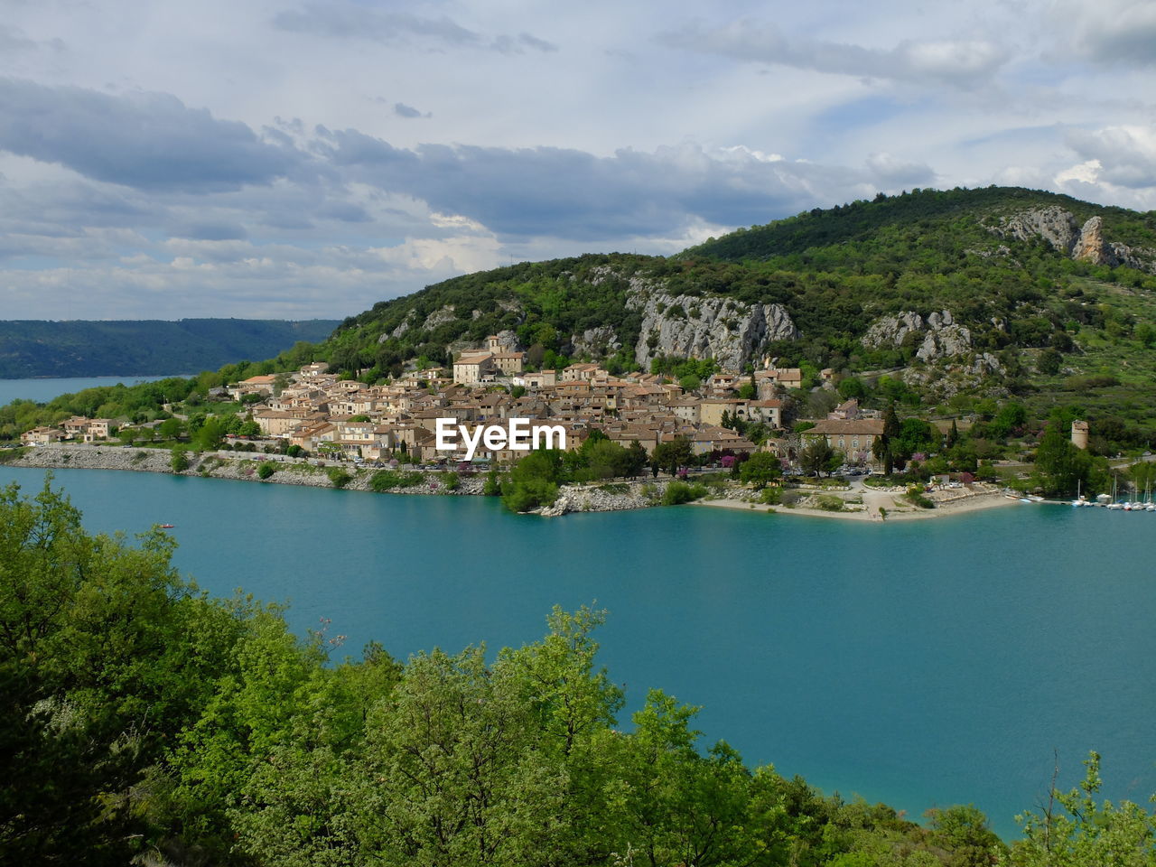 Scenic view of townscape by sea against sky