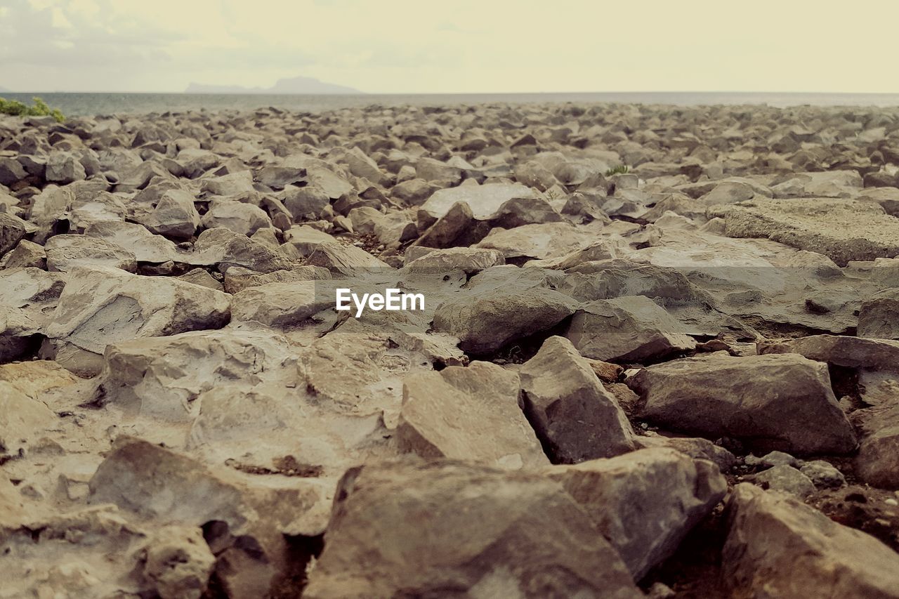 Close-up of rocks on beach against sky