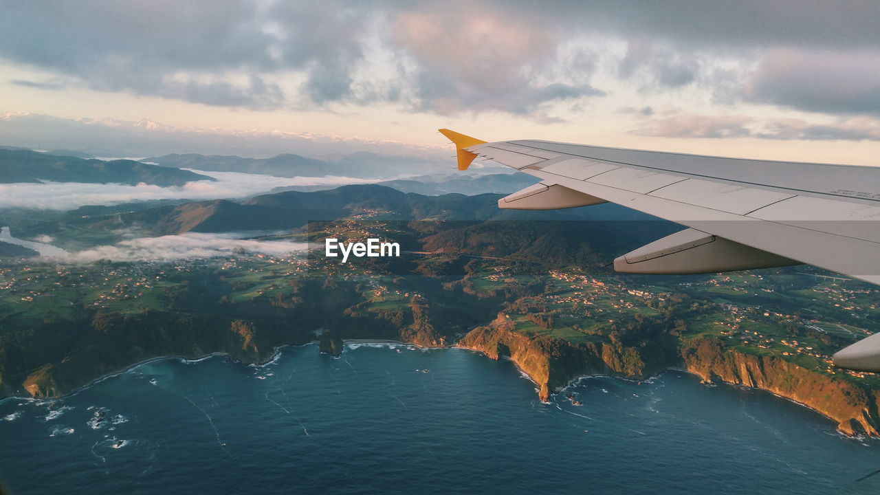 Airplane flying over sea against sky