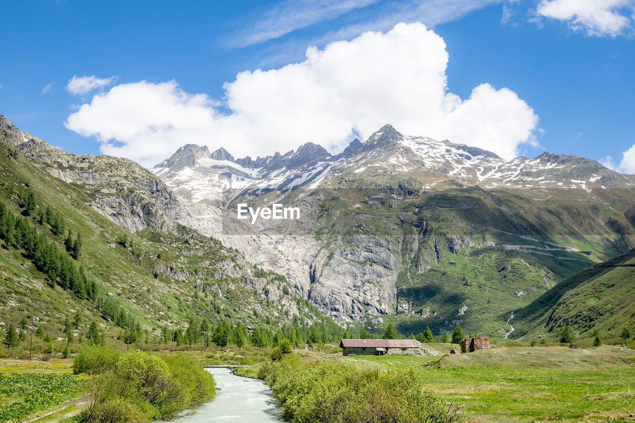 mountain, environment, scenics - nature, landscape, beauty in nature, sky, mountain range, nature, land, plant, cloud, valley, mountain pass, travel, travel destinations, snow, grass, water, tree, highland, tranquility, tranquil scene, cold temperature, no people, meadow, mountain peak, tourism, green, blue, snowcapped mountain, activity, non-urban scene, pinaceae, road, pine tree, forest, plateau, outdoors, footpath, rural scene, coniferous tree, field, day, summer, lake, pine woodland, wilderness, leisure activity, vacation, winter, walking, transportation, idyllic, trip, environmental conservation, holiday, social issues, adventure, plain, outdoor pursuit, springtime, architecture