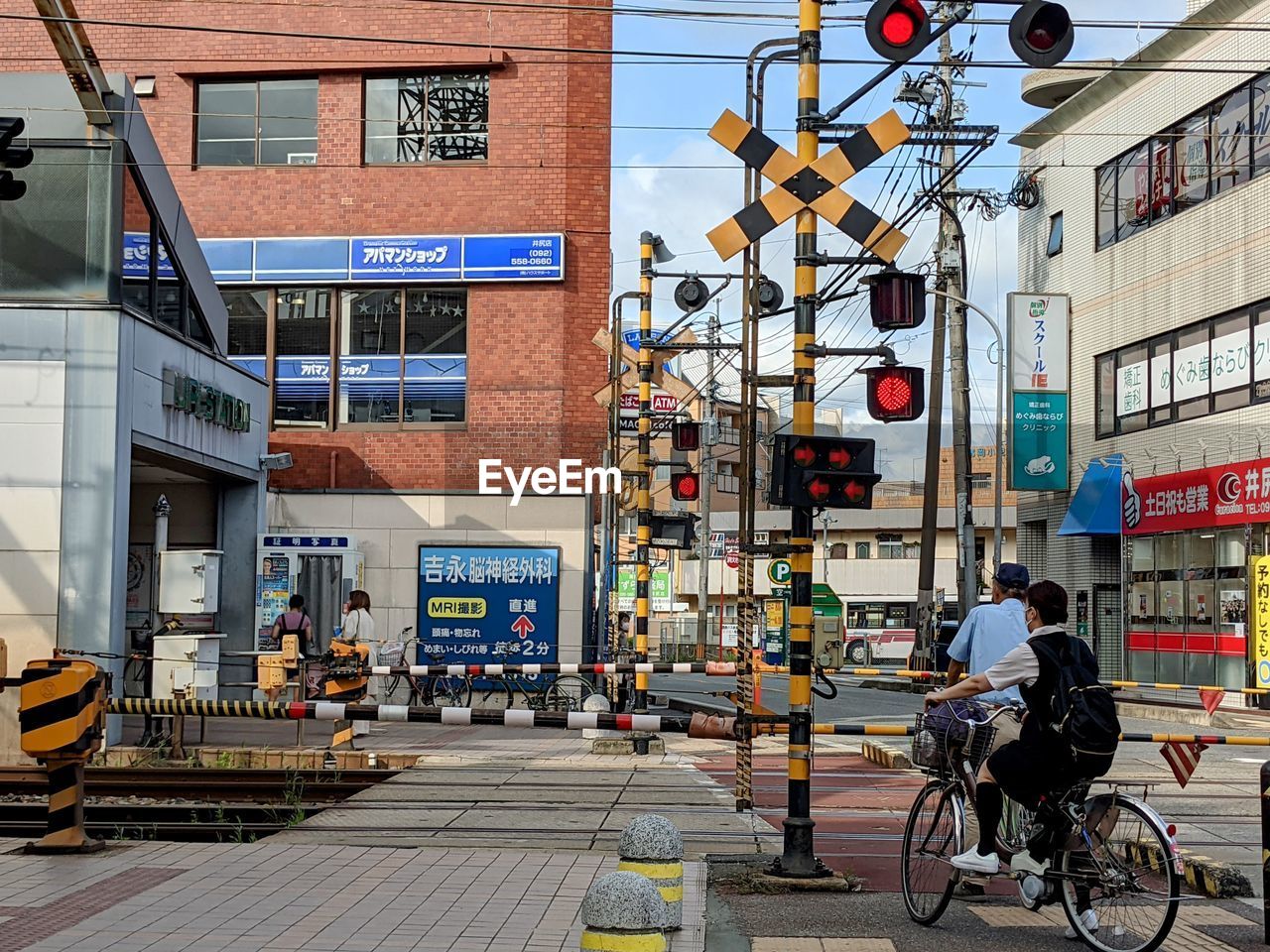 PEOPLE RIDING BICYCLE ON STREET AGAINST BUILDING