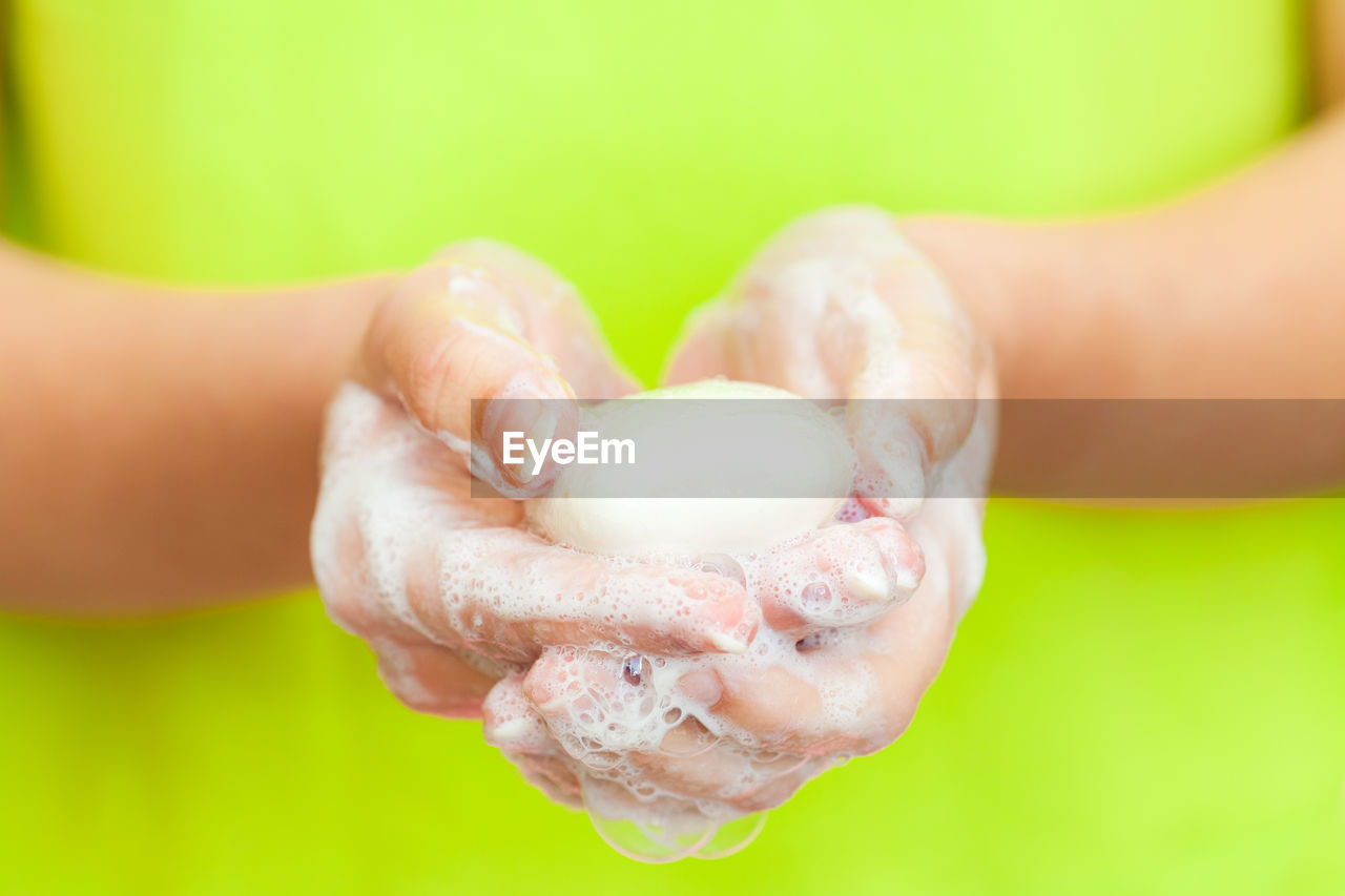 CLOSE-UP OF HAND HOLDING ICE CREAM IN PLATE