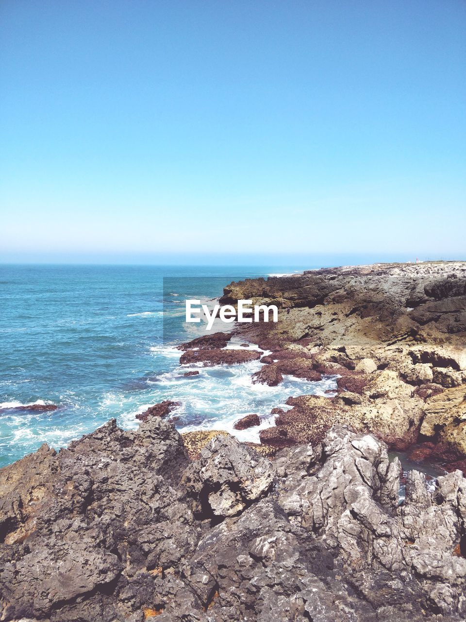 Scenic view of sea against clear blue sky during sunny day