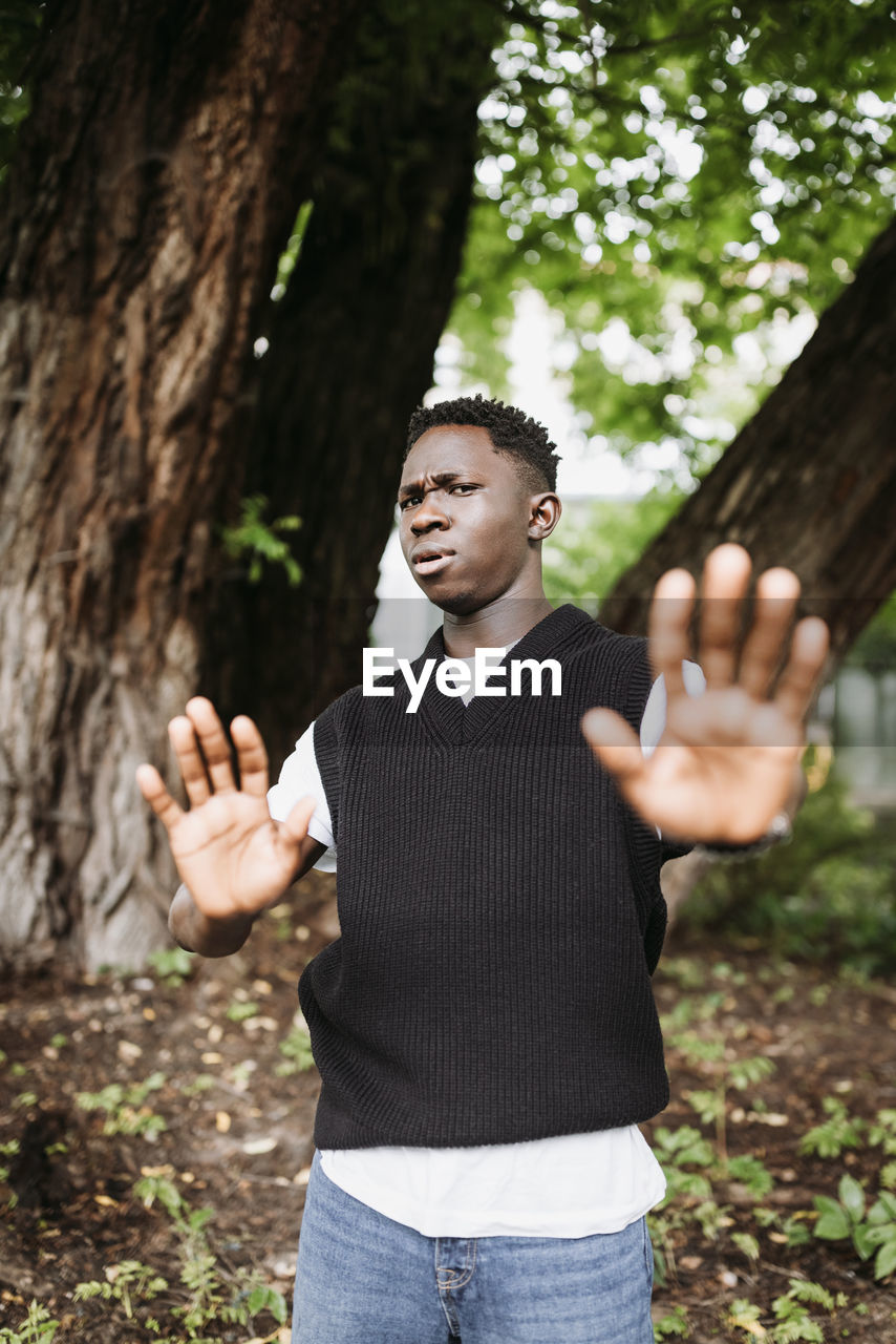 Shocked young 20s african man doing no stop sign with palms of hands