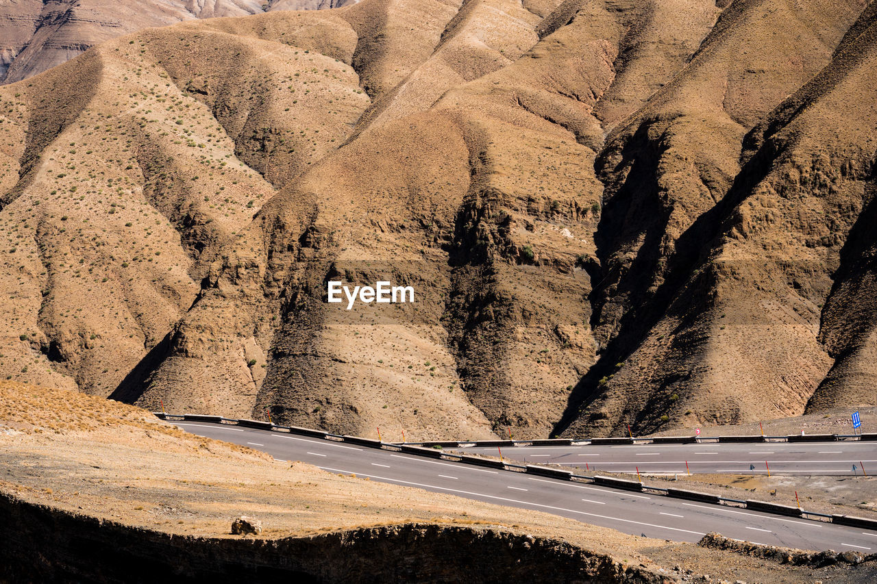 HIGH ANGLE VIEW OF ROAD ALONG TREES ON LAND