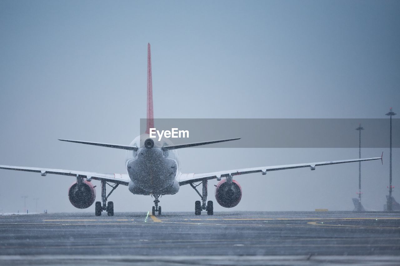 Winter day at the airport. airplane taxiing to runway at snowing.