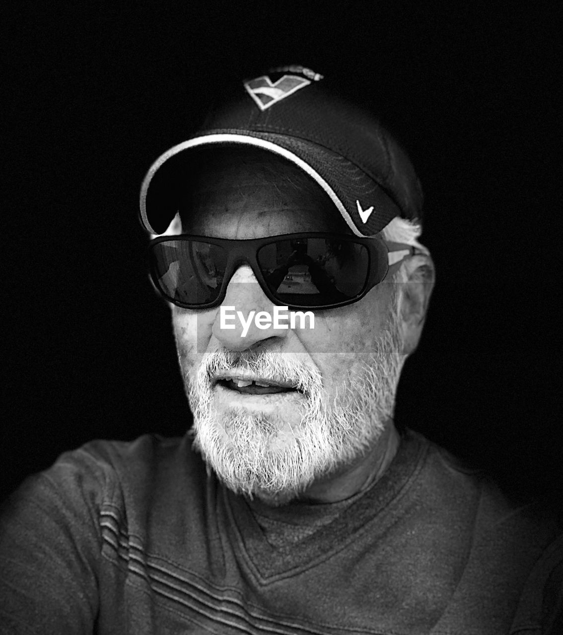 black, portrait, one person, adult, black and white, men, black background, glasses, headshot, monochrome, white, monochrome photography, studio shot, sunglasses, clothing, facial hair, person, indoors, vision care, beard, eyewear, fashion, front view, darkness, looking at camera, human face, senior adult, cap, moustache, mature adult, goggles, lifestyles, emotion