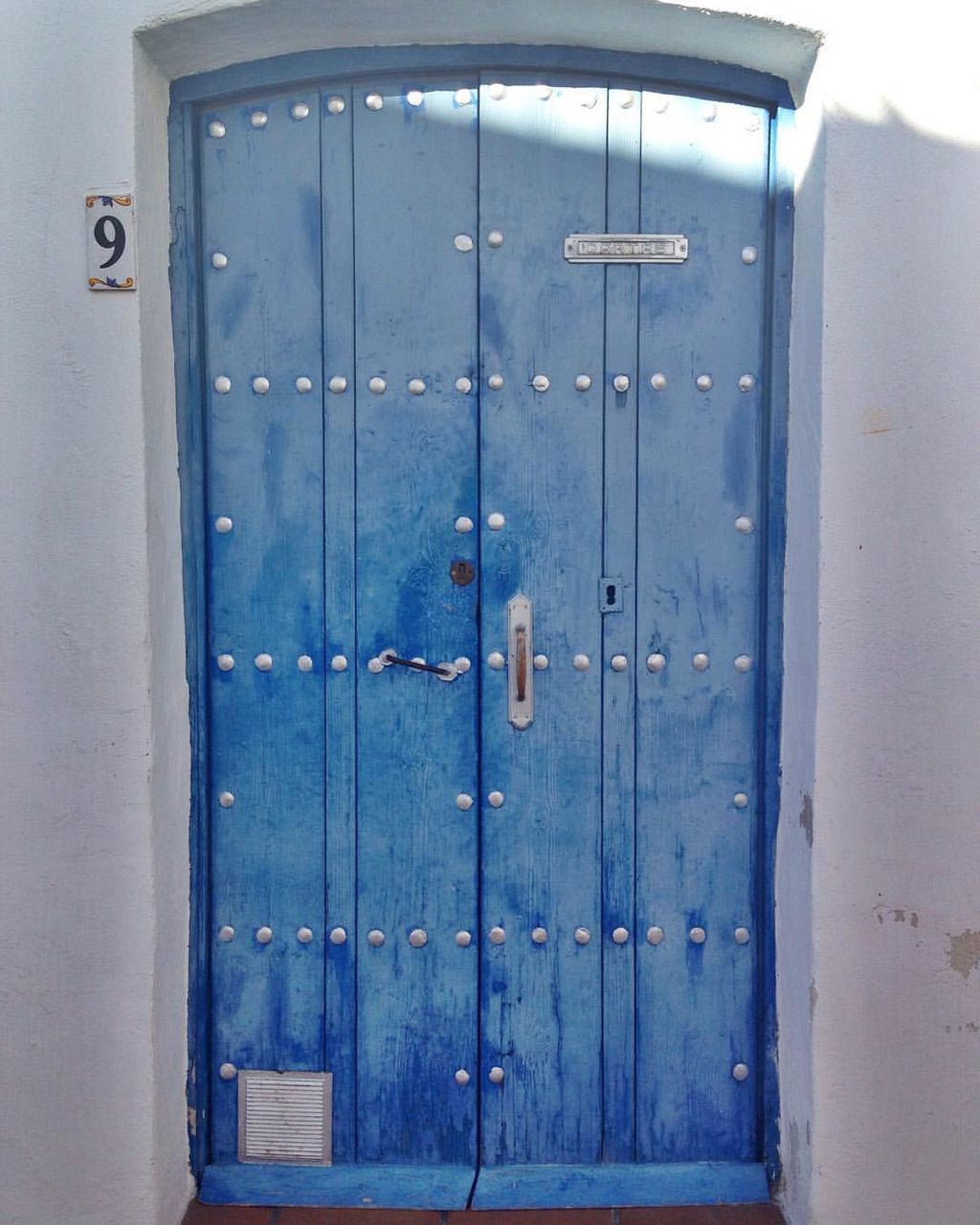 CLOSE-UP OF CLOSED DOOR OF BLUE METAL