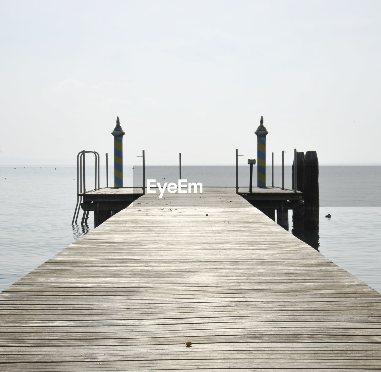 Wooden pier on sea against sky