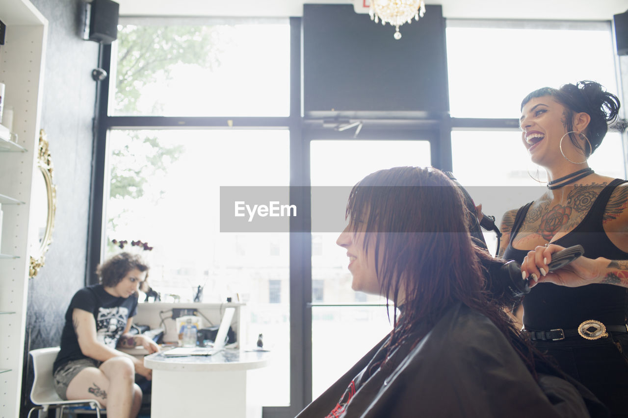 A hair dresser styling a customer's hair.