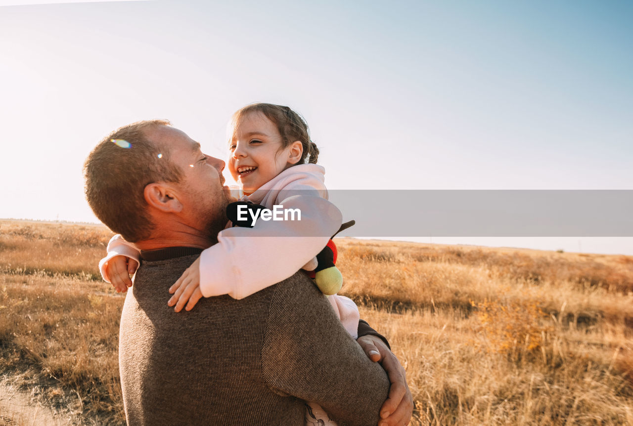 Happy father and child having fun playing outdoors. smiling young dad and daughter 