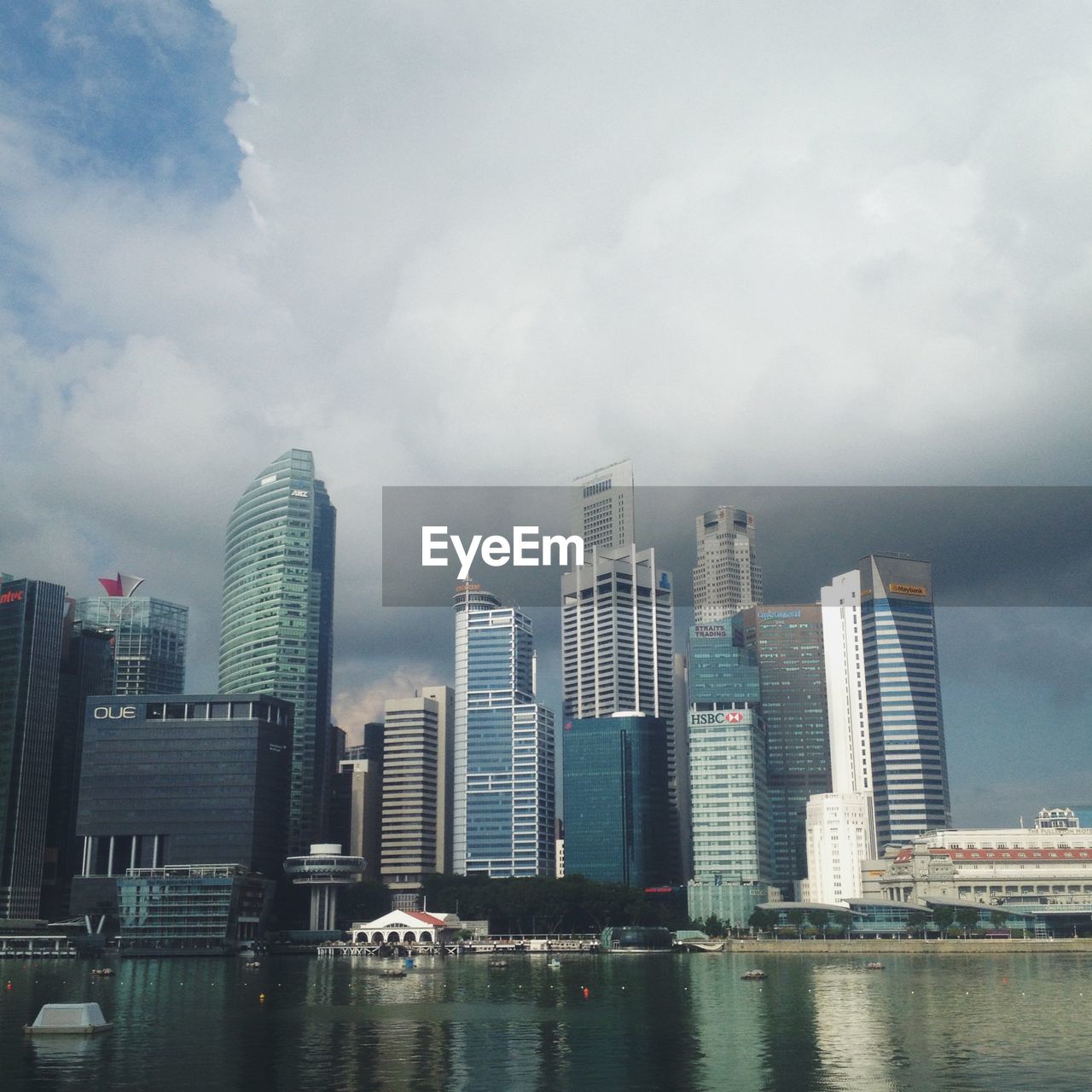 River by cityscape against cloudy sky