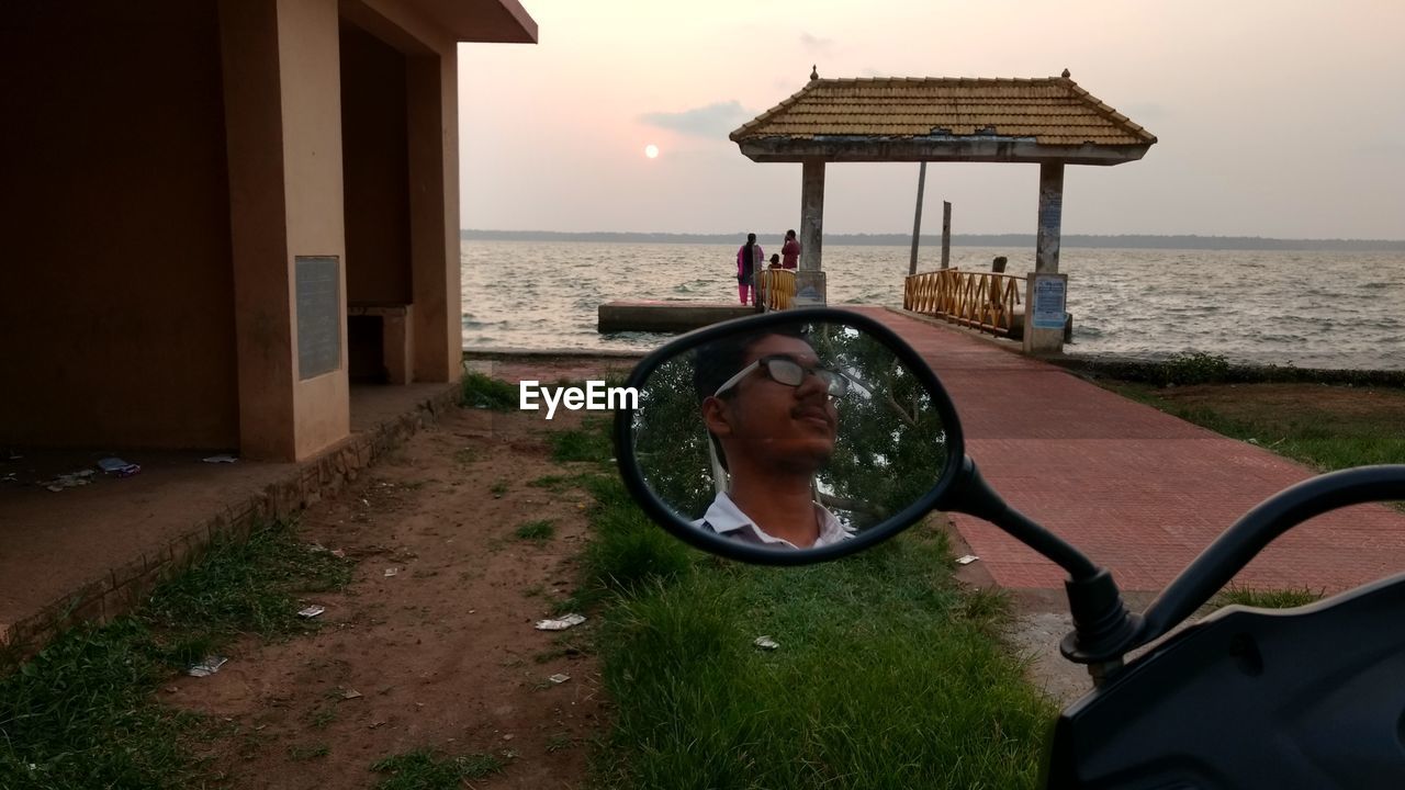 WOMAN IN SEA AGAINST SKY DURING SUNSET