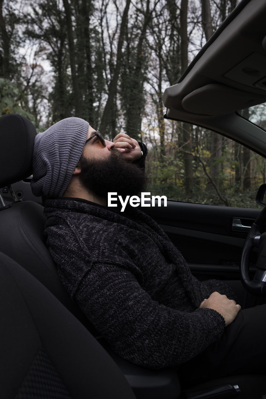 Man wearing knit hat sitting in car