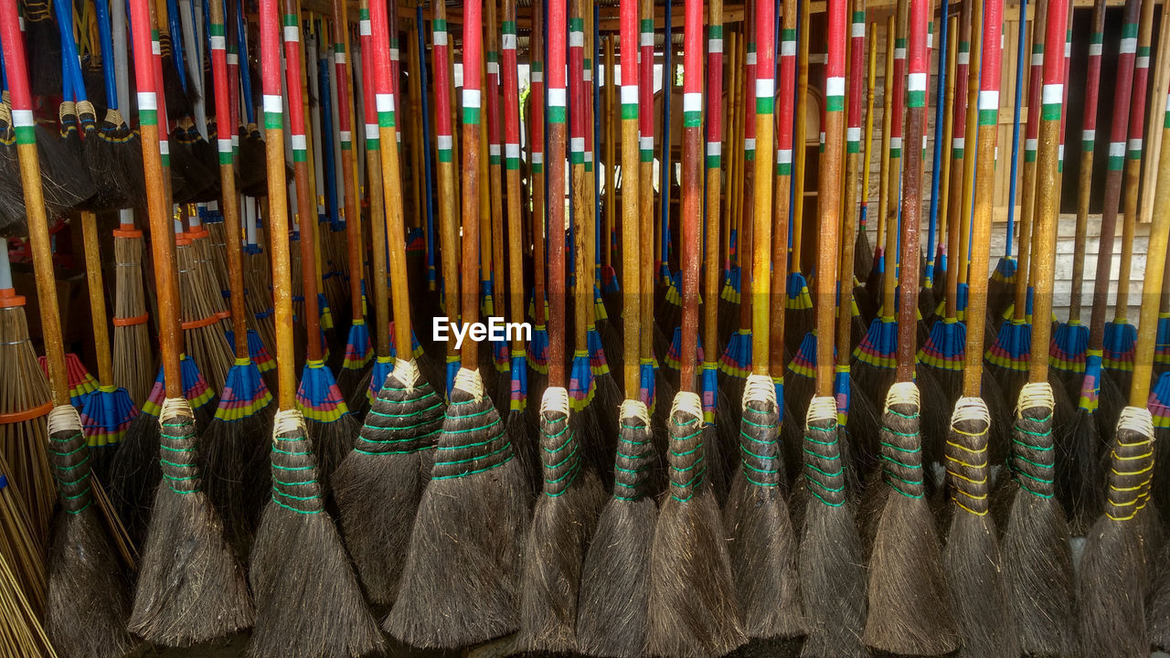 Close-up of multi colored brooms in row