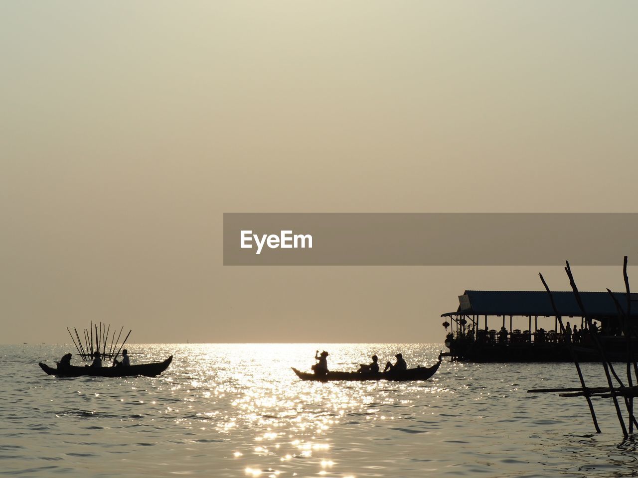 SILHOUETTE PEOPLE IN BOAT ON SEA AGAINST CLEAR SKY