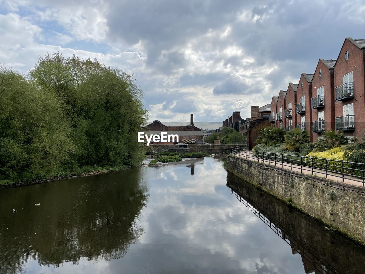 RIVER BY BUILDINGS AGAINST SKY