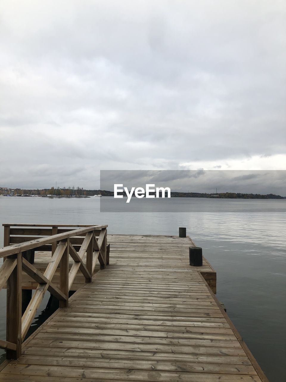 PIER OVER SEA AGAINST CLOUDY SKY