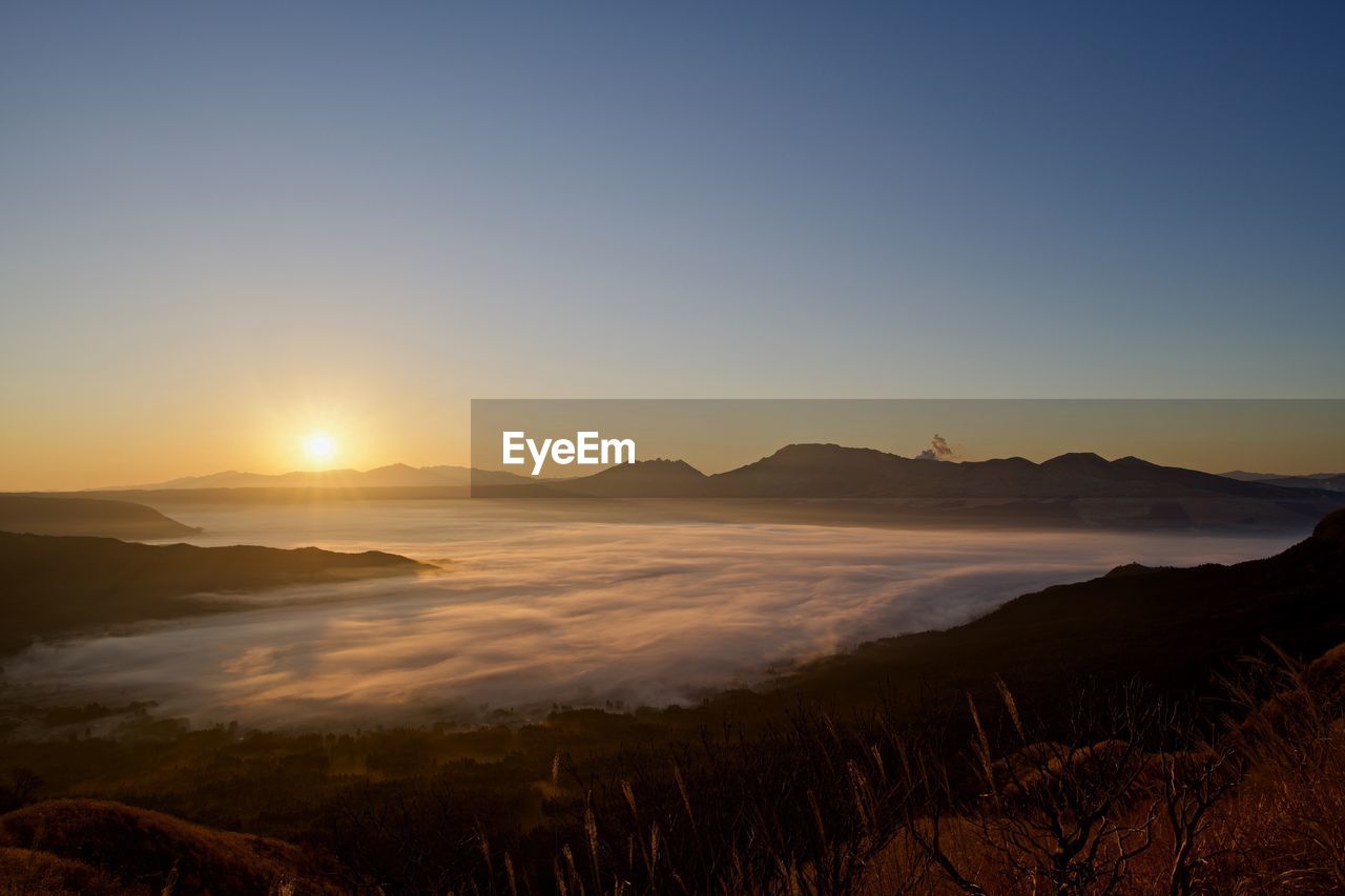 Scenic view of landscape against clear sky during sunset