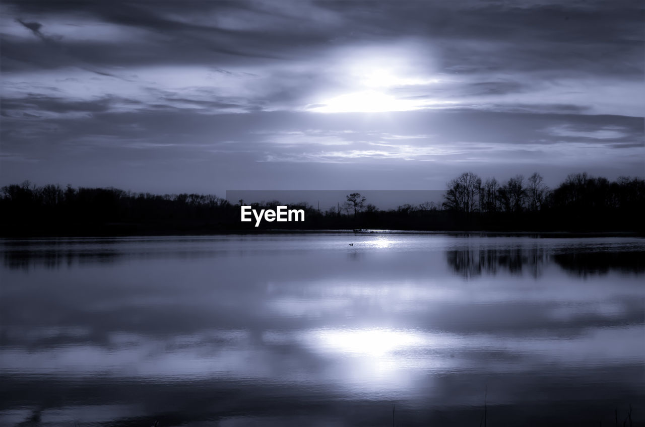 SILHOUETTE TREES BY LAKE AGAINST SKY