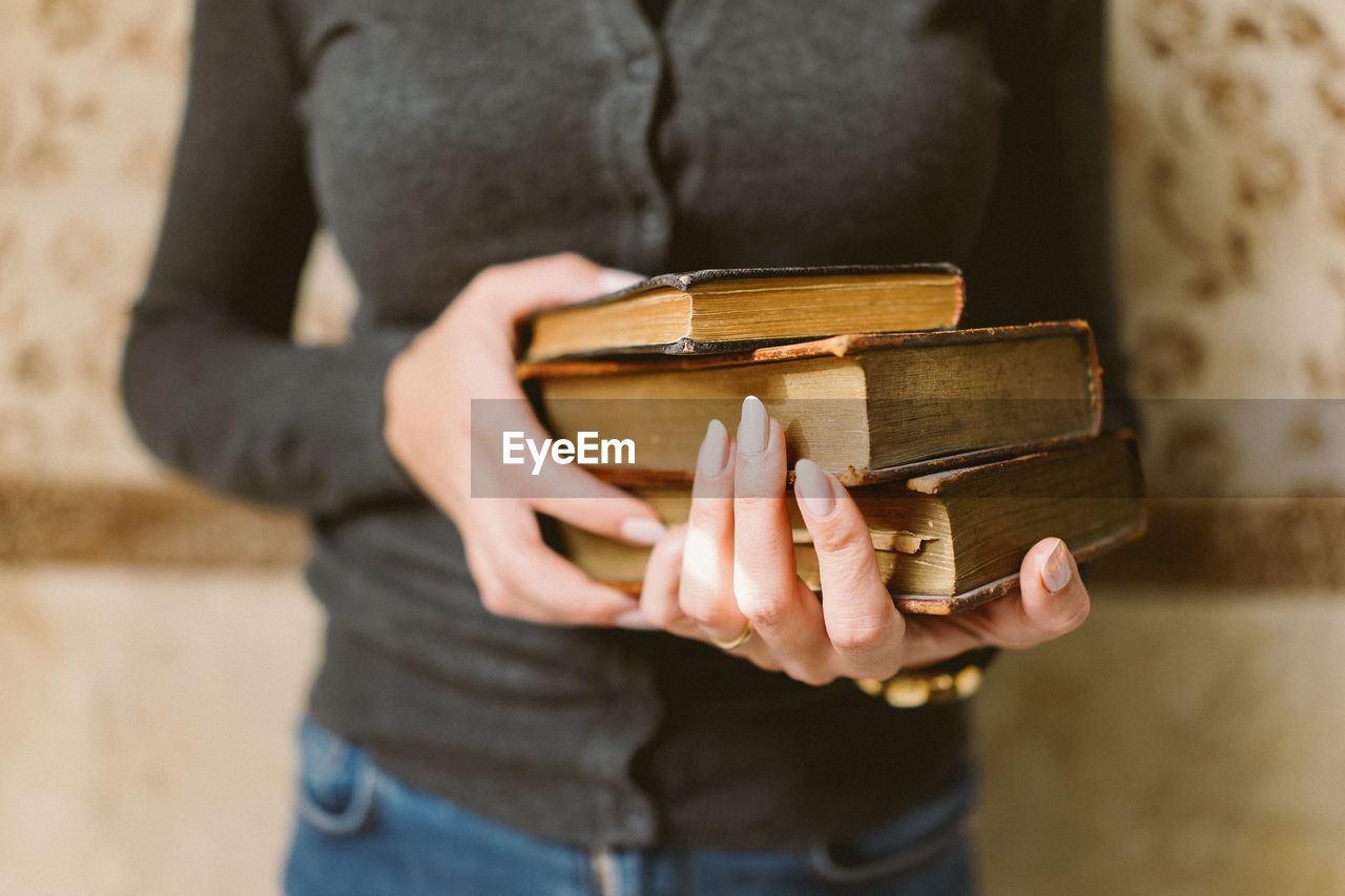 Midsection of man holding book