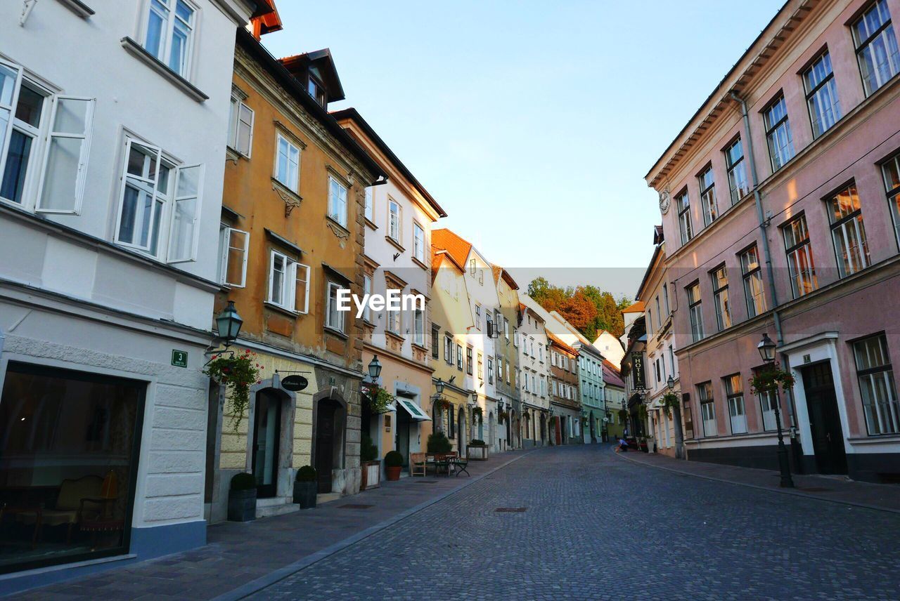 Street amidst buildings against clear sky