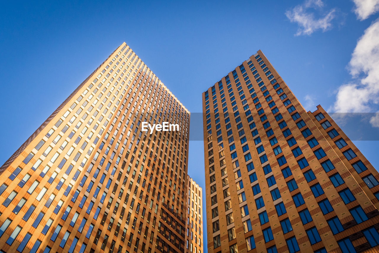 Low angle view of modern buildings against clear blue sky