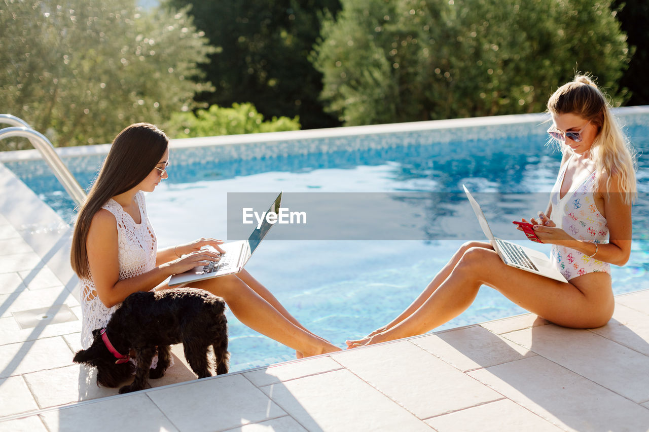 side view of young woman with dog sitting in boat